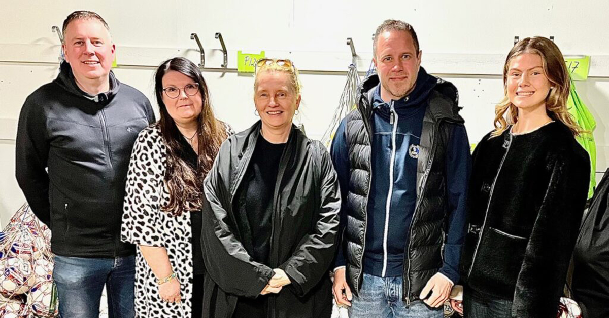 Två män och tre kvinnor poserar på en gruppbild