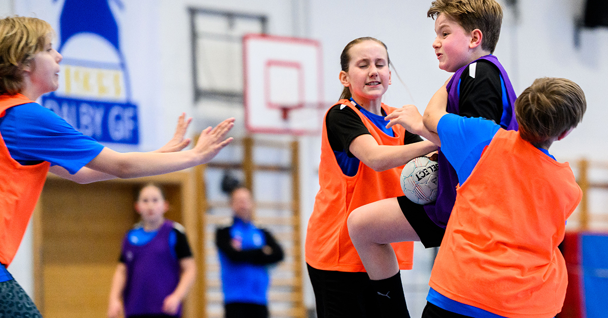 Unga handbollsspelare blockerar en motståndare