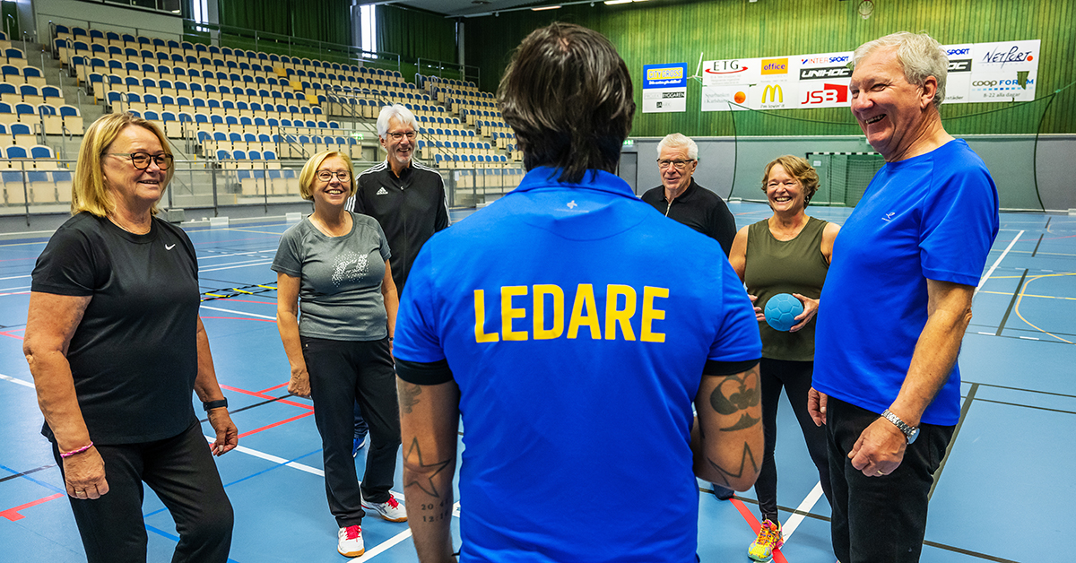 Sex män och kvinnor lyssnar på en ledare